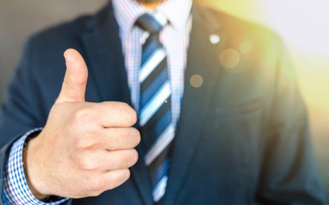 Man in suit making like gesture with his right hand to win back customers.