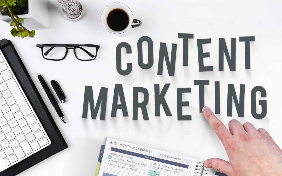 Playful letters that say CONTENT MARKETING on a white office desk surrounded by office objects.
